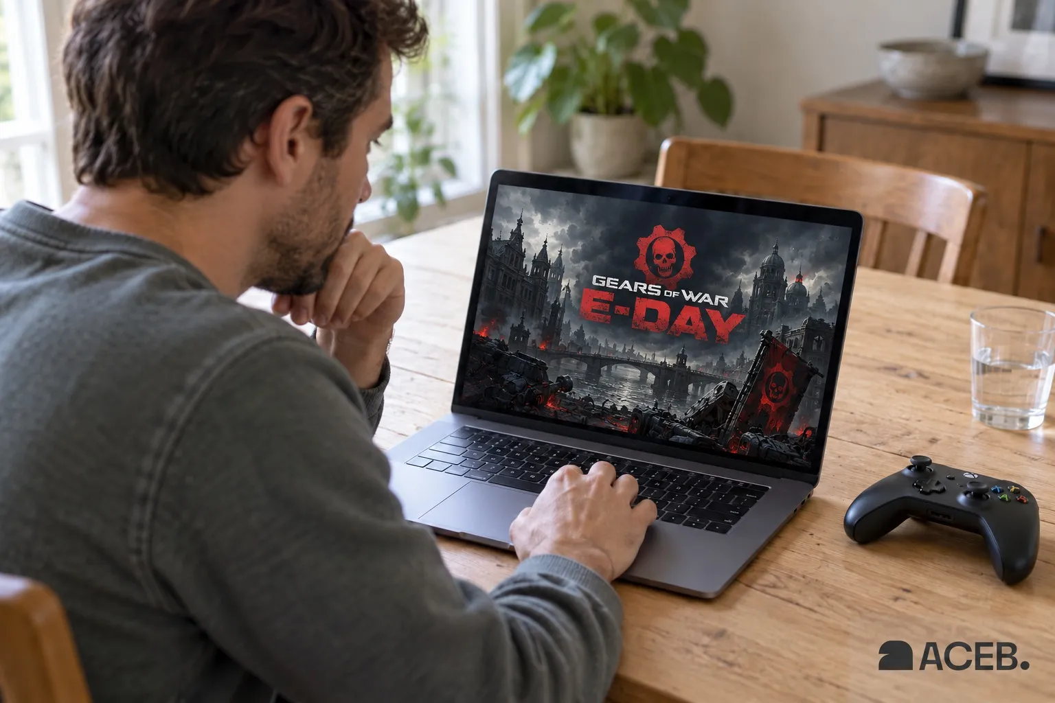 Man viewing Gears of War: E-Day artwork on a laptop with an Xbox controller beside it.